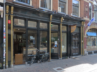 850168 Gezicht op de winkelpui van de 'Koekfabriek - bakkerij & winkel' (Schoutenstraat 7) te Utrecht.